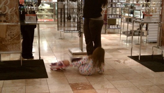 Child in Macy's throwing her baby doll around