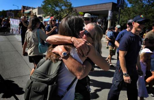 Spice Jones, left, gives Melanie Pray, a firefighter with the Boulder Rural Fire Protection District, an emotional hug Sunday on the Pearl Street Mall in Boulder during a parade to thank the local crews that fought the Fourmile Canyon fire. ( Judy DeHaas, The Denver Post )
